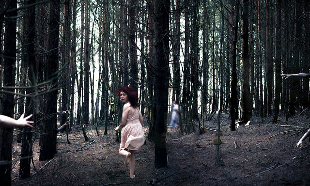 girl running away scared in forest